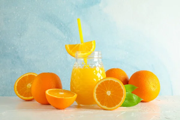 Glass jar with fresh orange juice and tubule, oranges on white t — Stock Photo, Image