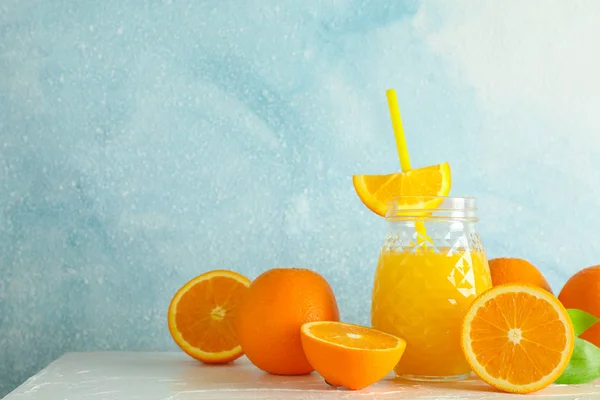 Glass jar with fresh orange juice and tubule, oranges on white t — Stock Photo, Image