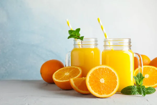 Γυάλινα βάζα με φρέσκο χυμό πορτοκαλιού και σωληνίσκο, πορτοκάλια και μέντα — Φωτογραφία Αρχείου