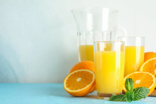 Composition with fresh orange juice in glassware, mint and woode — Stock Photo, Image