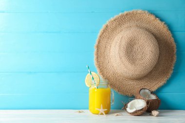 Hasır şapka, hindistan cevizi, taze portakal suyu ve beyaz denizyıldızları 