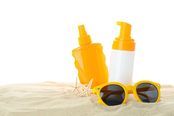 Солнцезащитные кремы с морской звездой и солнцезащитные очки на чистом песке — стоковое фото