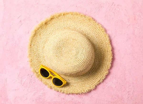 Солом'яний капелюх і сонцезахисні окуляри на кольоровому фоні, простір для тексту і — стокове фото