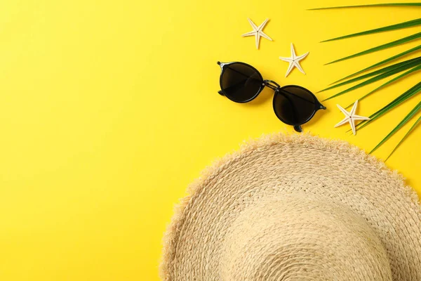 Hasır şapka, güneş gözlüğü, denizyıldızları ve palmiye yaprağı renkli backgro — Stok fotoğraf