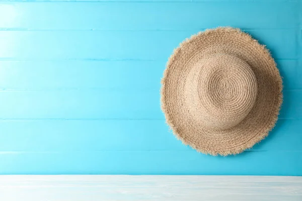 Sombrero de paja sobre mesa blanca contra fondo de color, espacio para tex —  Fotos de Stock