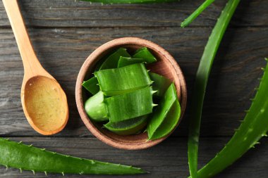 Aloe vera yaprakları ve ahşap masa, closeup ve üst vie dilimleri