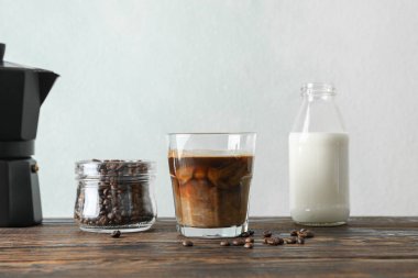 Hafif arka plana karşı ahşap masa üzerinde kahve zamanı aksesuarları