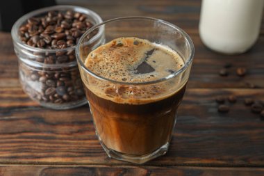 Ahşap masada taze kahve ve kahve çekirdekleri Cam, uzay fo