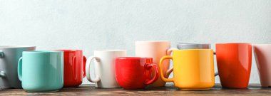 Açık arka plana karşı ahşap masa üzerinde çok renkli bardaklar, boşluk