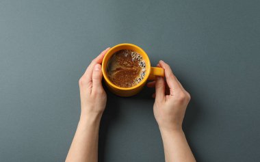 Kadın elleri siyah backgr üzerinde köpükköpük ile kahve fincan tutun