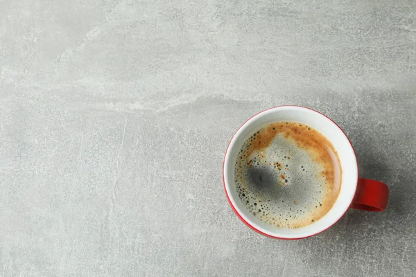 Šálek kávy na šedý stůl, horní pohled a prostor pro text — Stock fotografie
