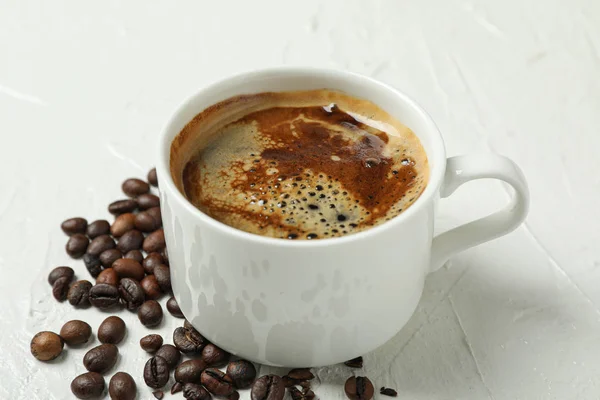 Secangkir kopi dengan busa berbusa dan biji kopi di backgro putih — Stok Foto