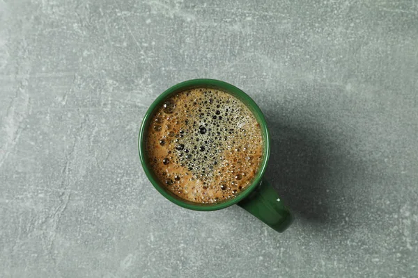 Šálek kávy s zpěněné pěnou na šedém pozadí, pohled shora a — Stock fotografie