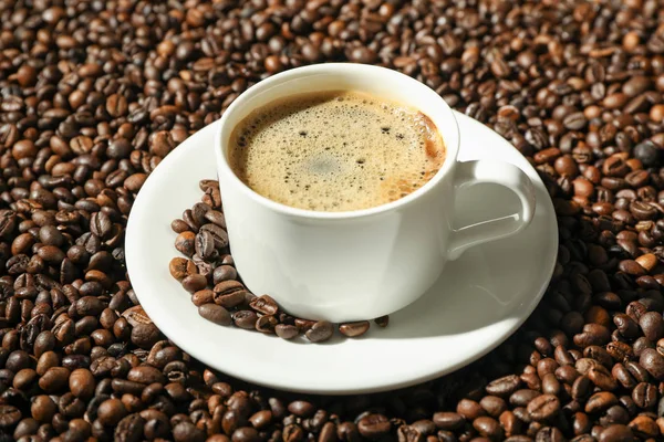 Tazza di caffè con schiuma schiumosa su sfondo fagioli, spazio per te — Foto Stock