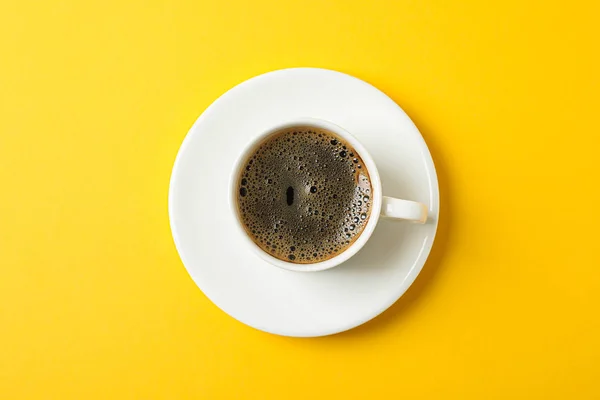 Cup of coffee with frothy foam on color background, space for te — Stock Photo, Image