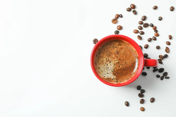 Cup of coffee with frothy foam and coffee beans on white backgro — Stock Photo, Image