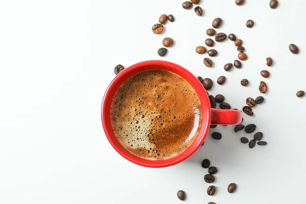 Tazza di caffè con schiuma schiumosa e chicchi di caffè su sfondo bianco — Foto Stock