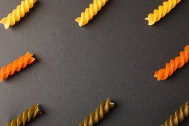 Siyah arka plan üzerinde çok renkli makarna ile düz döşeme kompozisyon