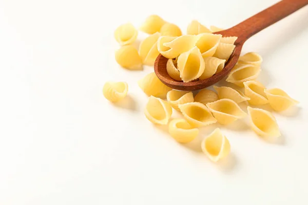 Cuchara de madera con pasta sobre fondo blanco, espacio para texto. Seco — Foto de Stock