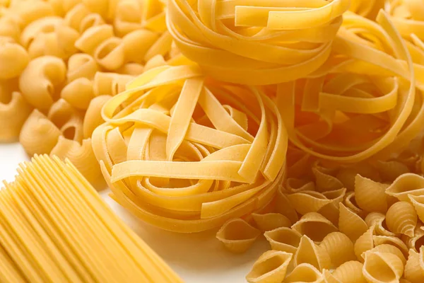 Verschillende pasta op witte achtergrond, close-up. Droog, ongekookt geheel — Stockfoto