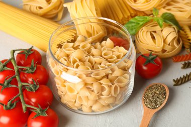 Beyaz arka planda makarna, domates ve baharatlar ile kompozisyon,