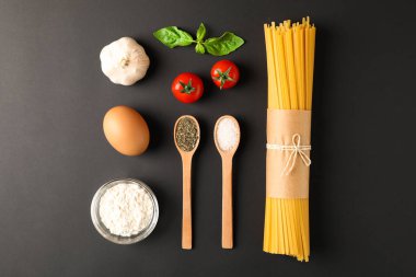 Siyah arka plan üzerinde makarna malzemeleri ile düz yatıyordu kompozisyon,