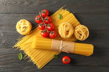 Ahşap arka planda makarna, domates ve fesleğen ile kompozisyon,