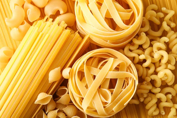 Verschillende pasta als achtergrond, close-up. Droge ongekookte hele pasta — Stockfoto