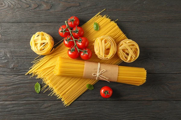 Composition avec pâtes, tomates et basilic sur fond bois , — Photo