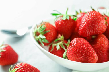 Beyaz ahşap backgrou taze çilek ve kaşık ile Plaka