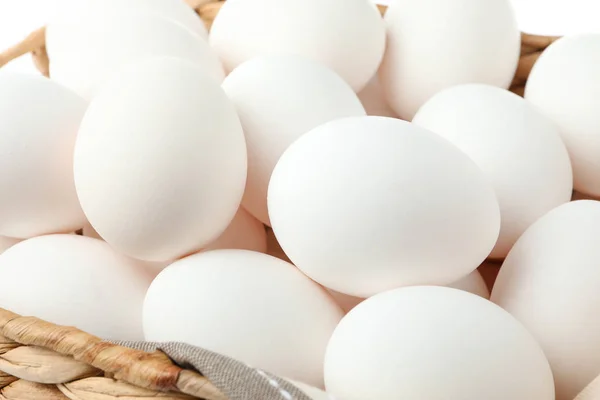 Курячі яйця з кухонним рушником у солом'яному кошику як фон, c — стокове фото
