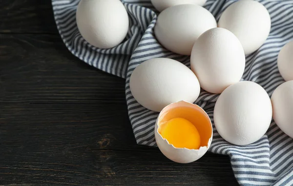 Ahşap sekmesinde karton kutu ve mutfak havlusu beyaz tavuk yumurtası — Stok fotoğraf