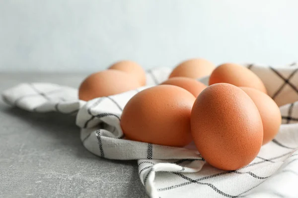 棕色鸡蛋在厨房毛巾在灰色桌子上对光 — 图库照片
