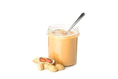 Cam kavanozda krem fıstık ezmesi, fıstık ve kaşık izole 