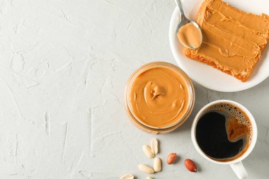 Fıstık ezmesi, fıstık, kahve, kaşık ve p ile cam kavanoz