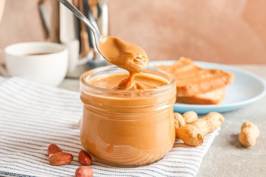 Açık kahverengi karşı gri masada nefis fıstık ezmesi kahvaltı 