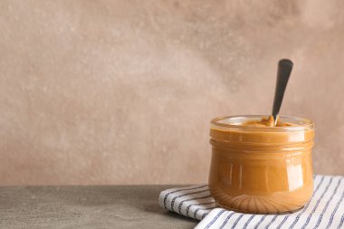 Fıstık ezmesi ve kaşık ile cam kavanoz ve Woo üzerinde mutfak havlusu