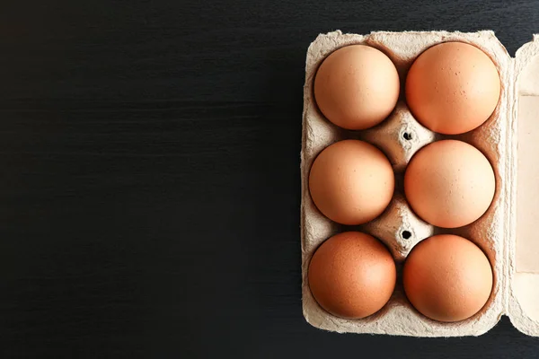 검은 배경에 판지 상자에 갈색 닭 계란, 공간 — 스톡 사진