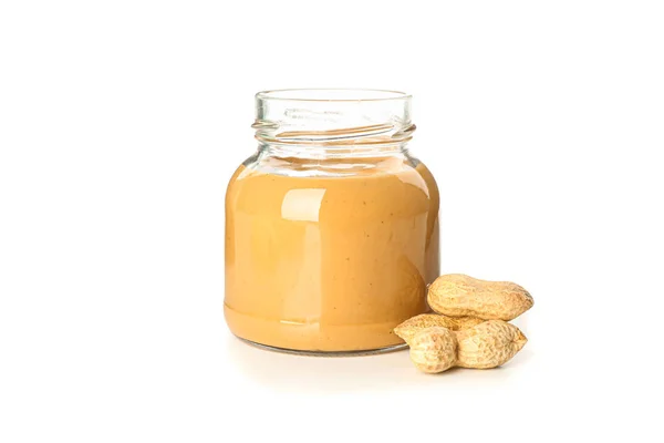 Manteiga de amendoim cremosa em frasco de vidro e amendoim isolado em b branco — Fotografia de Stock
