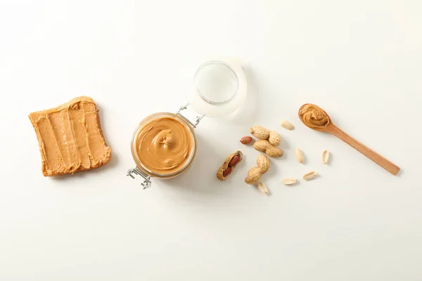 Flat lay composition with peanut butter sandwich, glass jar, pea