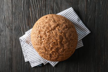 Ahşap arka planda mutfak havlusu üzerine ekmek, metin ve 