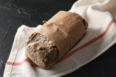 Ahşap backgro karşı siyah masa üzerinde mutfak havlusu üzerinde Çavdar ekmeği