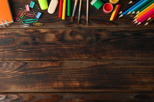 Ahşap arka plan üzerinde okul malzemeleri ile Düz yatıyordu kompozisyon, 