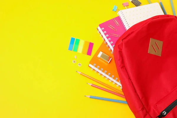 Composição de leigos planos com mochila e material escolar na cor — Fotografia de Stock