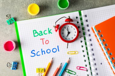 Gri arka plan, üst görünüm üzerinde okul malzemeleri ile kompozisyon