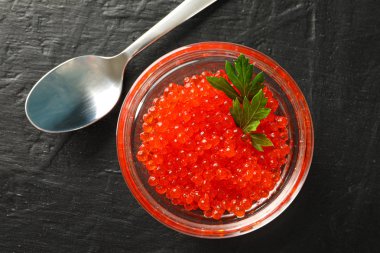 Siyah arka plan üzerinde havyar ve kaşık ile Cam kavanoz, t için alan