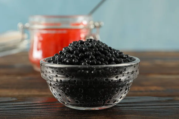 Glasburkar med kaviar på träbord, utrymme för text — Stockfoto