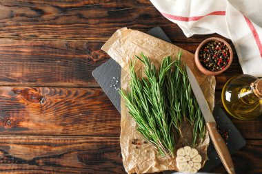 Biberiye, yağ, biber, sarımsak ve ahşap bıçak ile Kompozisyon