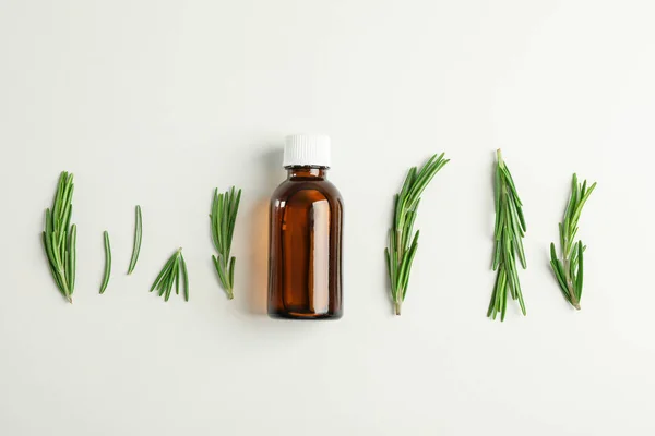 Flat lay composition with rosemary oil and leaves on white backg — Stock Photo, Image