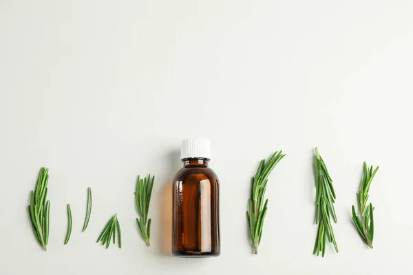 Flat lay composition with rosemary oil and leaves on white backg — Stock Photo, Image